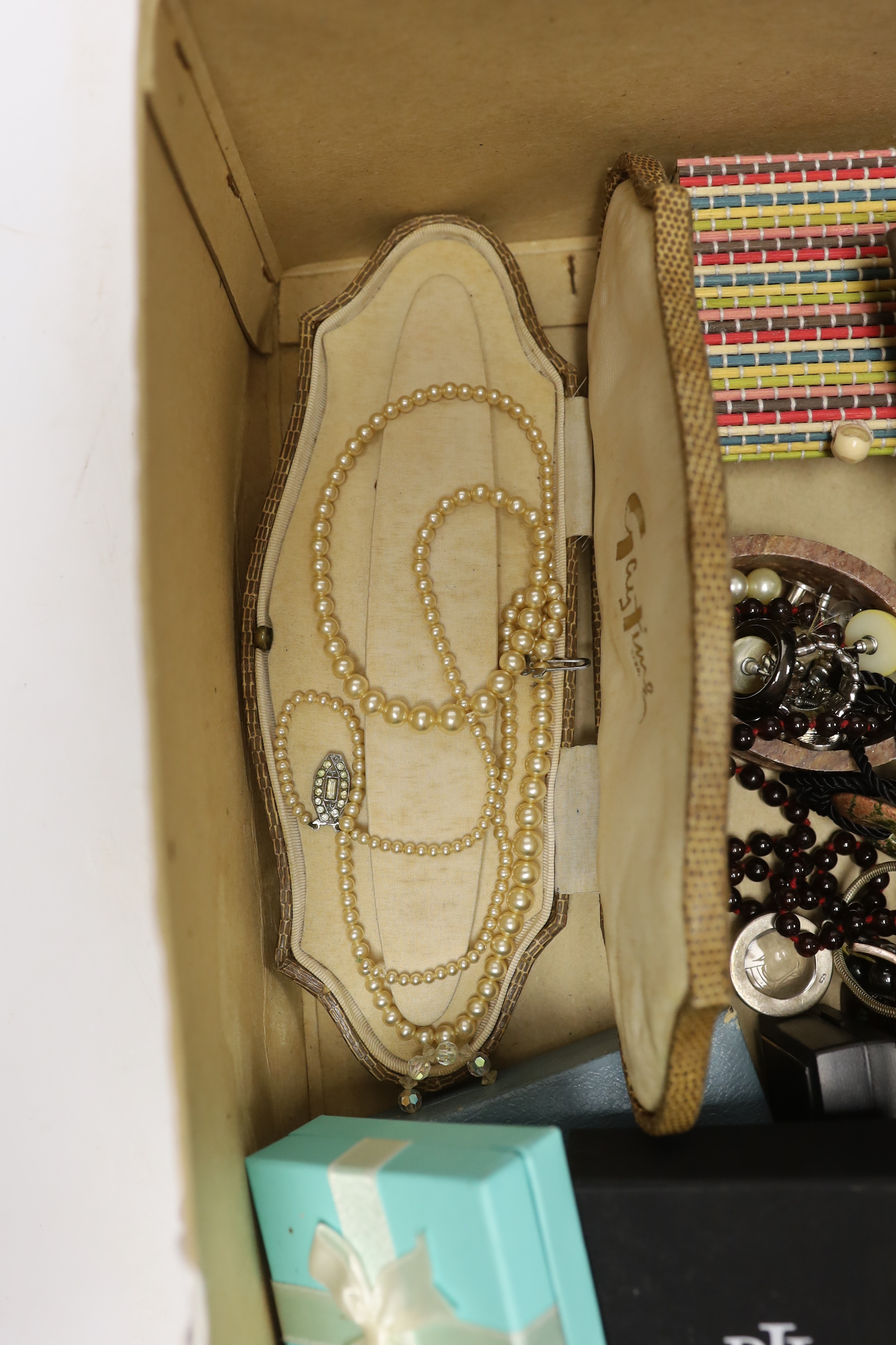 A group of assorted costume jewellery including a garnet necklace, amethyst pendant, etc.